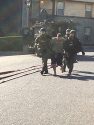 Christopher Clark in handcuffs behind brought out of the building by deputies