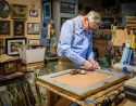 Artist Jack Cassinetto working in-studio to finish a framing