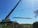 New pipe and protective steel casing being hoisted inot position