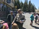 Undersheriff Bill Pooley hands stickers to kids at the Twain Harte Dog Parade