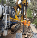 Heavy equipment across Hwy 26 building a new retaining wall during post Feb 14 2019 storm repairs