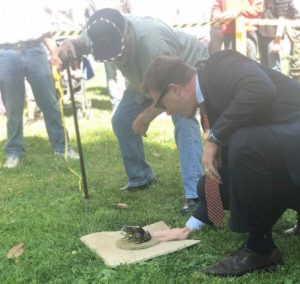 Borgeas on right sizes up a frog at the 45th Annual Capitol Frog Jump