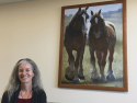 Artist Kathleen Dunphy by one of her donated artworks to Valley Springs Health and Wellness Center