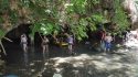 Natural Bridges visitors wading under an arch