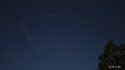 Perseids meteors in a photo taken Aug 13 2019 next to a passing aircraft that appears to be a red dotted line