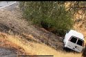 Van slides off roadway during rain