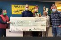 SAF Executive Director Darrell Slocum in middle presents check to WATCH organizers