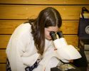young student looking into a microscope