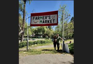 Heather and Ben Gunderson under banner for Murphys Farmers Market