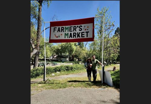Heather and Ben Gunderson under banner for Murphys Farmers Market
