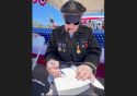 Lt. Dennis Thompson signs a book at the 2024 Father's Day Fly-In (photo by Traci Williams-O'Neil)