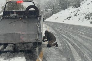 Driver pulled over on the fast lane shoulder and putting on chains—CHP photo