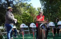 Clois Irwin speaks, with Joseph Mathiesen-Powell to the left