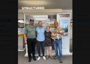 (L-R) Justin Gates (Managing Partner and Operations Manager), Petter Fritz (Managing Partner, CRO, and Son-in-law of Dan Pinnell), Ashley Pinnell (Marketing Manager, daughter of Dan Pinnell, spouse of Petter), and Dan Pinnell (founder, holding grand-pup Lucy).