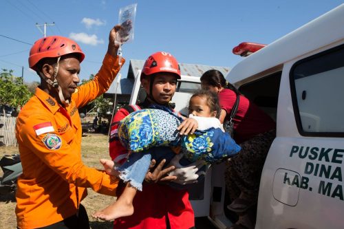 People await aid after powerful earthquake in Indonesia, in photos