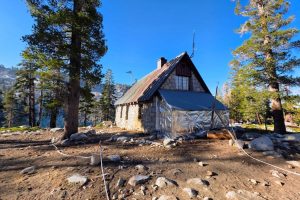The Ostrander Ski Hut firewood shed wrapped in fire-resistant material, with sprinklers staged around the structure—YNP photo